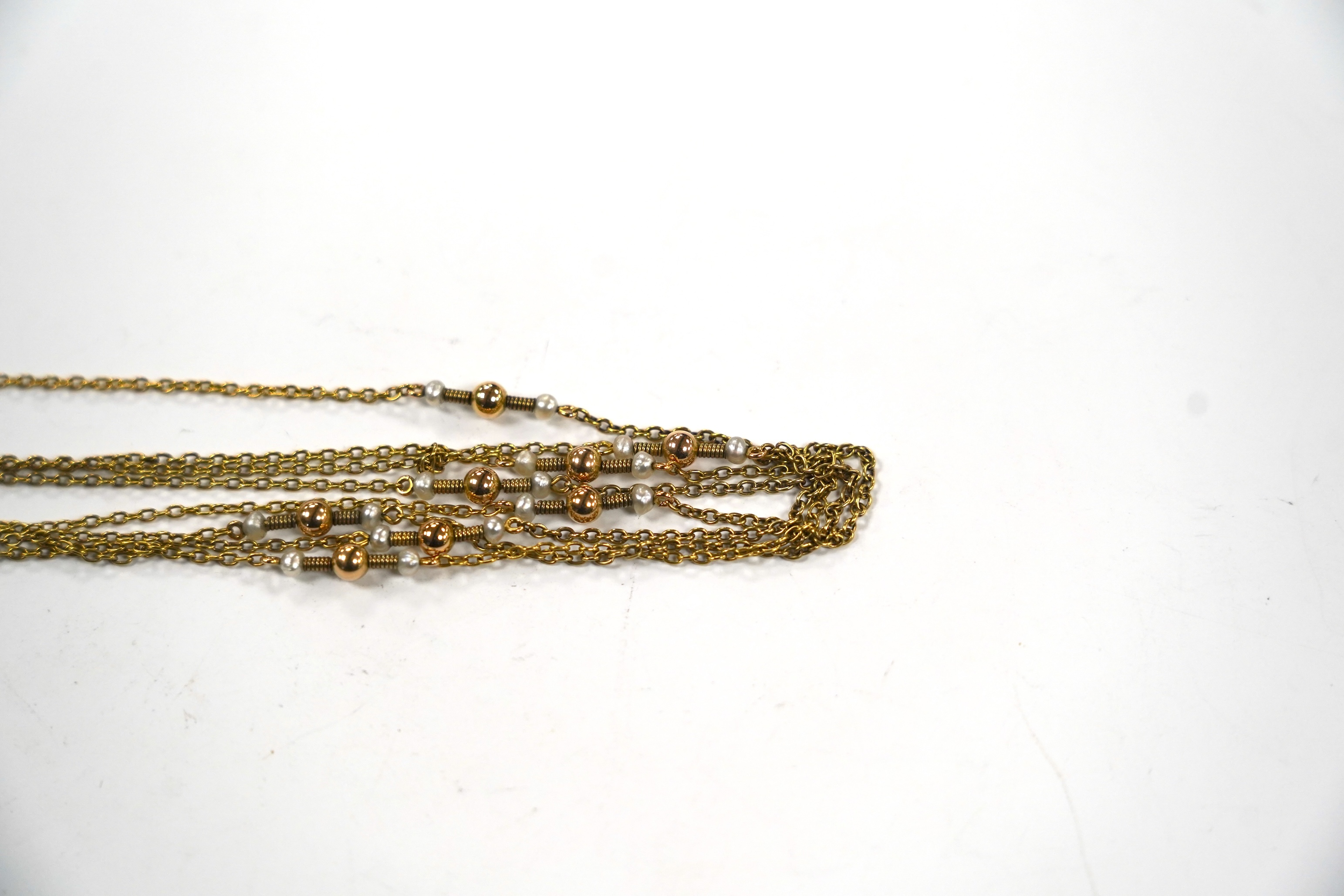 A 10k yellow metal and seed pearl set guard chain, 146cm, gross weight 14.2 grams.